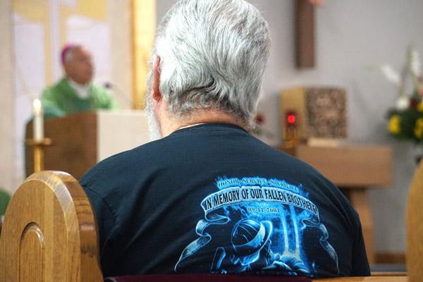 Retired firefighter Larry McDonald, who worked 40 years at the Highway 286 East Volunteer Fire Department in Faulkner County, listens to Bishop Taylor’s homily during the Blue Mass honoring first responders at St. Joseph Church in Conway. (Aprille Hanson photo)