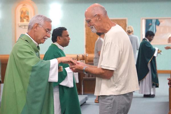 Jim Breakfield, a U.S. Navy veteran and parishioner at St. Joseph Church in Conway, receives Communion from Bishop Taylor during the Blue Mass Sept. 11. (Aprille Hanson photo) 