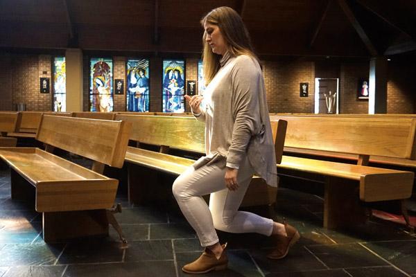 Wendy Floriani genuflects before entering a pew at Our Lady of the Holy Souls in Little Rock. It is an act of worship to genuflect or bow toward the Blessed Sacrament in the tabernacle or the altar. (Aprille Hanson)