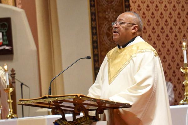 Father Warren Harvey, the bishop's liaison for the Diocesan Council for Black Catholics, reads the Gospel during the annual MLR Memorial Mass. (Malea Hargett photo) 