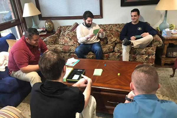 Seminarians Pablo Quintana (left), Colton Ketter, Sam Stengel, Joseph Jones and Thomas DePrez play a board game April 3 in the House of Formation. There are currently 15 seminarians, three priests and Bishop Anthony B. Taylor who are isolated in the house because of the COVID-19 threat. (Deacon Joseph Friend photo)