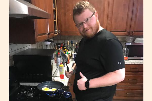 Seminarian Cory Eveld gives the thumbs up while cooking breakfast. A few seminarians have taken up different hobbies, like cooking, while “social distancing.” (Msgr. Scott Friend photo) 