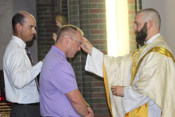 Bill Lampe (center) is blessed by associate pastor Father Jeff Hebert in the adoration chapel at St. Joseph Church in Conway in May 2019 when he joined the Catholic Church. His sponsor was Brent Bruich (left). (Carina Martinez photo)