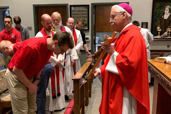 Seminarian Joel Brackett venerates the crucifix on Good Friday, April 10, at the House of Formation in Little Rock. Instead of the usual tradition of kissing or touching the cross, seminarians bow. (Pablo Quintana photo) (Not available for sale)