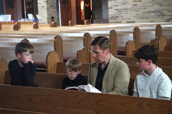 Edward Dodge, a parishioner at St. Joseph Church in Conway and teacher at Catholic High School in Little Rock, reads the Passion narrative from the Gospel of Luke to his sons, Kolbe, 8, (left), Sam, 10, and Eddie, 13, on Good Friday, April 10. (Aprille Hanson photo) 