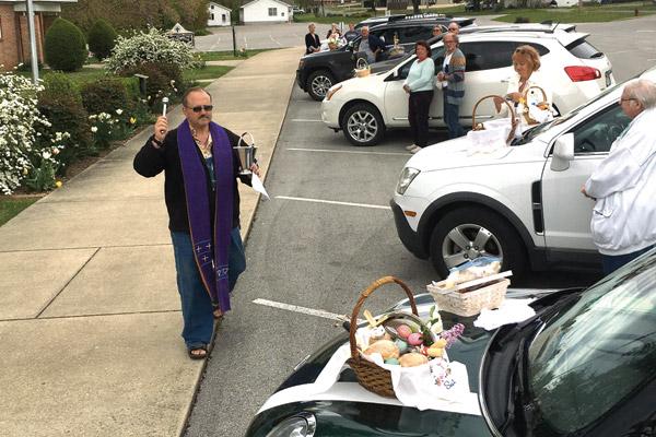 Father Norbert Rappold, pastor of St. Peter the Fisherman Church in Mountain Home, blesses Easter baskets April 11. Baskets were blessed in the parking lot at a distance. (Bob Wochner photo) (Not available for sale)