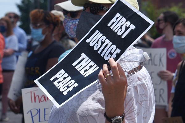 A woman attending the “Take a Knee - A Rally for Justice” June 6 holds a sign advocating justice for George Floyd and all black people killed by police brutality. Pax Christi Little Rock, a Catholic peace and social justice group, helped sponsor the rally which was also attended by some diocesan priests and area Catholics. Speakers called for change. (Aprille Hanson photo)