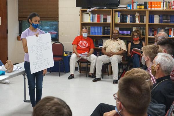 Jasmine Jones, of St. Bartholomew Church in Little Rock, holds a sign during a listening session July 2 for seminarians at the House of Formation in Little Rock, hosted by the Diocesan Council for Black Catholics. (Aprille Hanson photo)