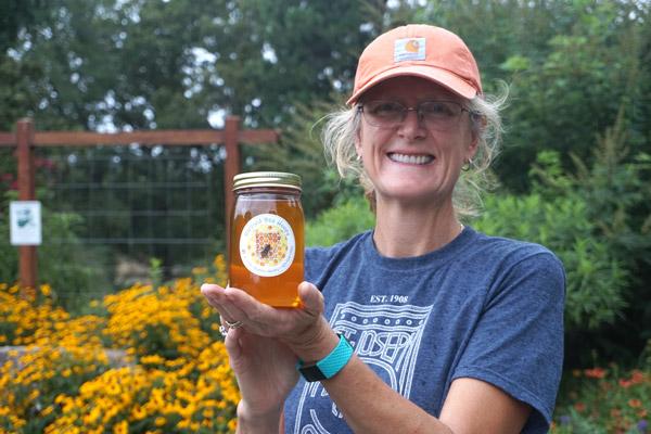 Volunteer Ruth Landers shows off a jar of Blessed Bee Honey, collected at the St. Joseph Apiary and sold at the center’s Farm Stand. (Aprille Hanson photo)