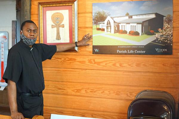 Father Leon Ngandu, SVD, pastor of St. Bartholomew Church, shows the architect’s rendering July 31 of the Parish Life Center that will be built next to the church and rectory in Little Rock. (Malea Hargett photo)