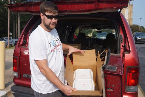 Immaculate Heart of Mary Church in North Little Rock (Marche) parishioner Chris Dailey shows off the packed up Polish Karnawal dinners before delivering them to St. Anne Church in North Little Rock Sept. 18. To lessen the crowds but still raise money with their Polish Karnawal, the parish took to-go meals to the parking lots of St. Anne, St. Joseph Church in Conway and St. Jude Church in Jacksonville. (Aprille Hanson photo)