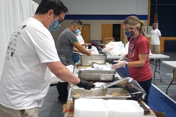 Before handing out to-go orders Sept. 18 at Immaculate Heart of Mary Church in North Little Rock (Marche) parishioners John Wolfe (left), Kasey Kollar, Juan Garcia and Becky May pack the dinners for the Polish Karnawal. (Aprille Hanson photo)