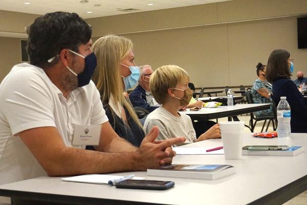 Dylan and Angie Potts, along with son Jude, listen to a speaker during an RCIA class at Christ the King Church in Little Rock Sept. 30. Candidates and elect are meeting socially distanced in the Family Life Center. (Aprille Hanson photo)