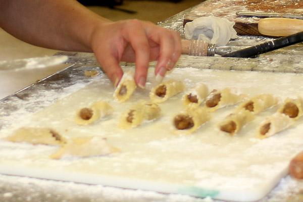 Pecan Kolackies are pastry folded around a sweet filling in this photo from a 2015 baking session at Sts. Cyril and Methodius Church in Slovak. The hand belongs to Aprille Hanson, associate editor of Arkansas Catholic and an inexperienced baker who was enticed to try her hand when reporting on the Slovak bakers. (Arkansas Catholic file)