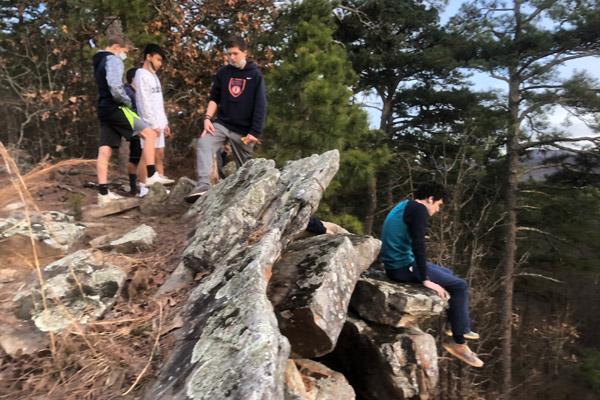 Subiaco Academy students Lane Wilson (left), Ben Dang, Delo Folson and Robert Valerio sit on a bluff Jan. 18 on Subiaco’s property, spanning 1,500 acres. The Outdoor Adventure Program was implemented at the beginning of the school year. (Nick McDaniel) 