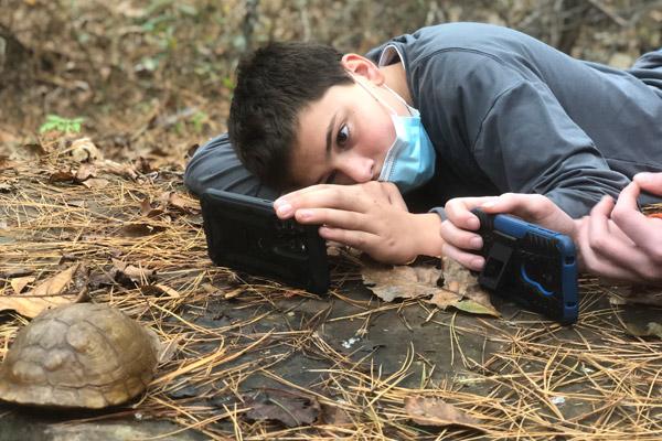 Subiaco Academy students Aiden Harris (center) and Peter Giebel take photos of a tortoise Oct. 25 at Mount Rich in the Mount Magazine wildlife refuge. Nick McDaniel said the Outdoor Adventure Program has been positive for the boys’ wellbeing. (Nick McDaniel) 