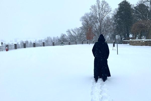 Brother Ephrem O’Brien, OSB, walks to the weather station and rain gauge northwest of the Subiaco Abbey building Feb. 15. The Benedictine monks have taken weather observations for the National Weather Service since 1897. (Brother Sebastian Richey, OSB, photo)