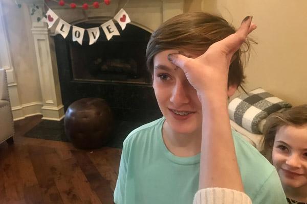 Valarie Edwards makes a cross of ashes on her son Micah’s forehead Feb. 17, while youngest daughter Layne waits her turn. The Edwards family brought home an Ash Wednesday kit from their church, Our Lady of the Holy Souls in Little Rock. (Photo courtesy of Edwards family)