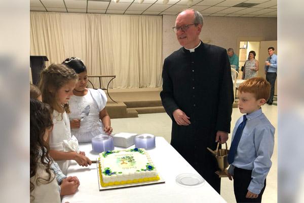 Father James West, who served as pastor at St. Edward Church in Texarkana before his death last year, celebrated two years ago with first communicants. (Courtesy Thompson family)