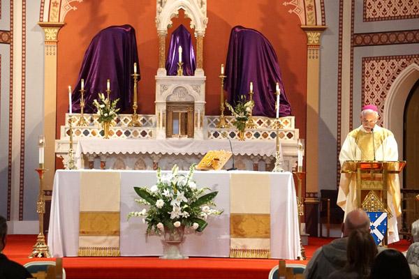 Bishop Anthony B. Taylor delivers his Holy Thursday homily April 1 at the Cathedral of St. Andrew. Statues in the church were draped with purple cloth until Holy Saturday. (Malea Hargett photo) 