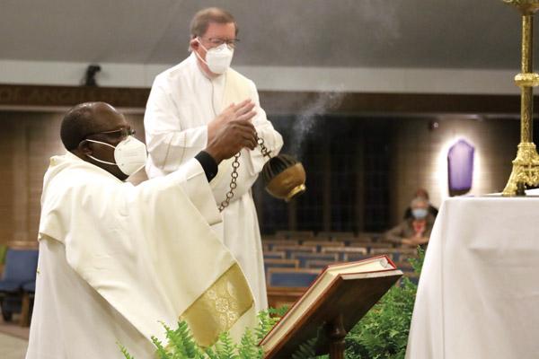 Father John Wakube, pastor of Immaculate Conception Church in North Little Rock, burns incense before the altar during Holy Thursday services April 1, as Deacon Chuck Farrar looks on. (Dwain Hebda photo) 