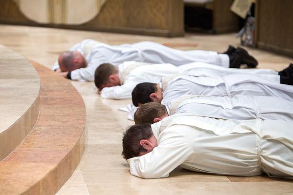 Fathers William Burmester (left), Stephen Hart, Ramsés Mendieta, Martin Siebold and Luke Womack lay prostrate in front of the altar during their 2017 ordination at Christ the King Church in Little Rock as congregants sing the litany of the saints. (Travis McAfee photo, Arkansas Catholic file)