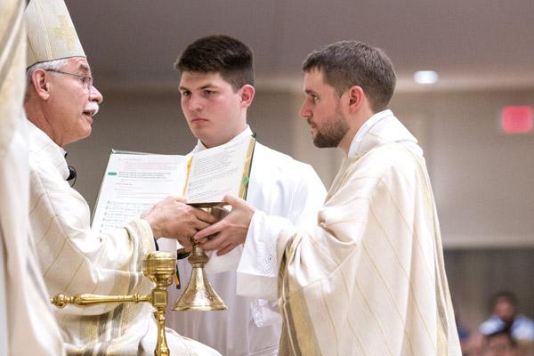 Bishop Anthony B. Taylor hands a paten and chalice to newly ordained priest Father Stephen Hart during his 2017 ordination Mass at Christ the King Church in Little Rock. (Travis McAfee photo, Arkansas Catholic file)