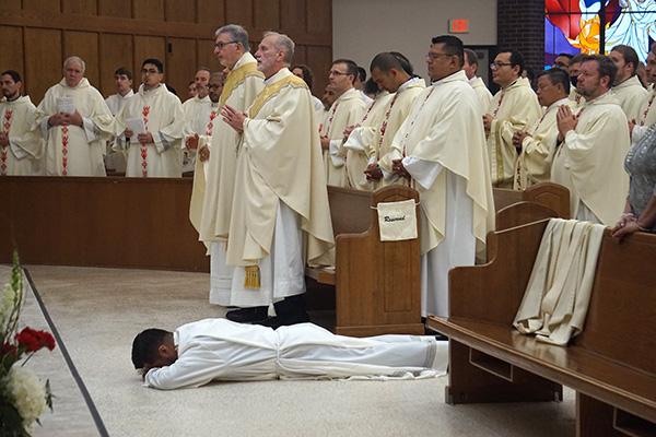 Jaime Nieto lays prostrate as priests, deacons and fellow congregants sing the litany of saints during his diaconate ordination May 21 at St. Raphael Church in Springdale. (Aprille Hanson Spivey photo) 