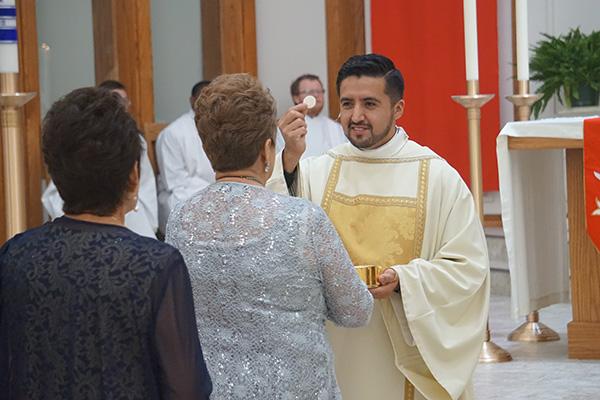 Deacon Jaime Nieto gives communion to his mother, Maria Del Carmen Nieto Bautista, during his diaconate ordination May 21 at St. Raphael Church in Springdale. (Aprille Hanson Spivey photo)
