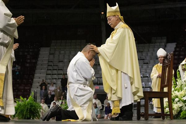 Bishop Anthony B. Taylor lays hands on Deacon Alex Smith May 29 during his priestly ordination. The elect officially become priests with the laying on of hands and the prayer of ordination. (Bob Ocken photo)