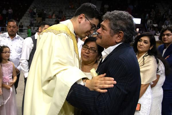 At the end of Mass, Father Omar Galván gives a blessing to his family, with a special hug for his parents Baltazar and Florina Galván of Fort Smith. (Bob Ocken photo)