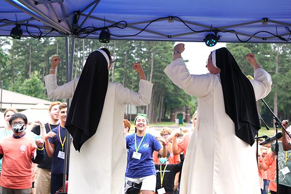 Sisters Catherine Luttmer and Mary Clare Bezner, Olivetan Benedictine nuns from Holy Angels Convent in Jonesboro, lead the hand motions while the crowd sang “Lean On Me.” (Malea Hargett photo) 