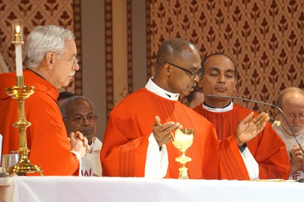 Jubilarian Father James Ibeh, CSSp, prays at the altar alongside Bishop Anthony B. Taylor (foreground left) and fellow jubilarian Father John Antony, JCL (foreground right), at the Cathedral of St. Andrew in Little Rock June 29. (Aprille Hanson Spivey photo)