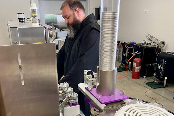 Brother Sebastian manages the canning line for a fresh batch of Country Monks craft beer. (Courtesy Arkansas PBS)