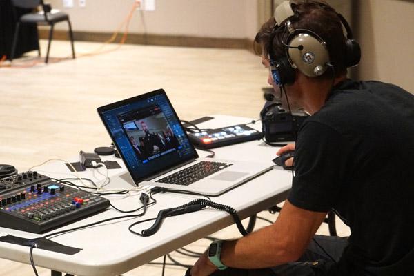 Travis McAfee monitors the livestream of Taste of Faith on YouTube and Facebook Aug. 7. McAfee, a member of St. Raphael Church in Springdale, oversaw production of the recorded videos and livestream production. (Malea Hargett photo)