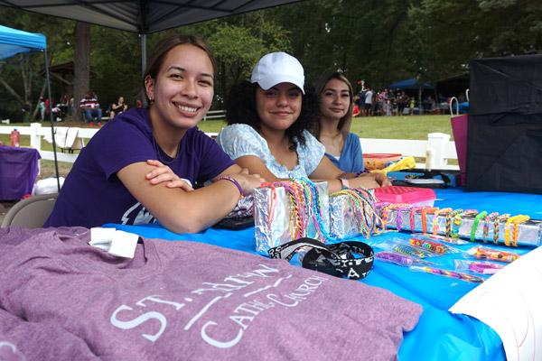St. Andrew parishioners Cristal Ponce, Abigail Garcia and Alondra Ponce smile at the T-shirt table during the annual parish festival Aug. 14 at the Danville city park. (Aprille Hanson Spivey photo) 
