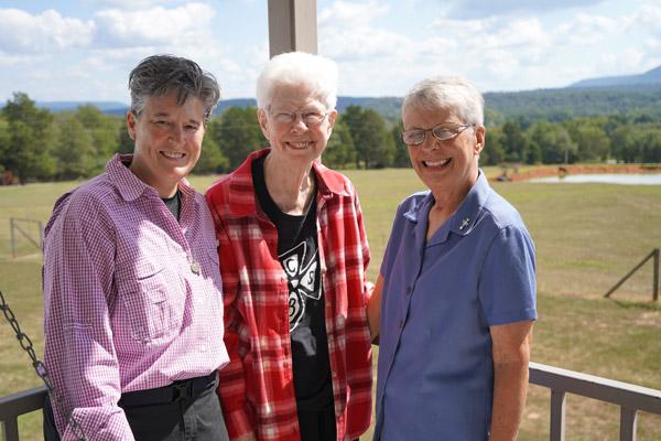 At the Hesychia House of Prayer, Sister Lisa Atkins, RSM (left), Sister Louise Sharum, OSB, and Sister Anita DeSalvo, RSM, smile in front of a view of the Ozark Mountains Sept. 16. Still a ministry of St. Scholastica, the Religious Sisters of Mercy are now helping lead it. (Aprille Hanson Spivey photo)