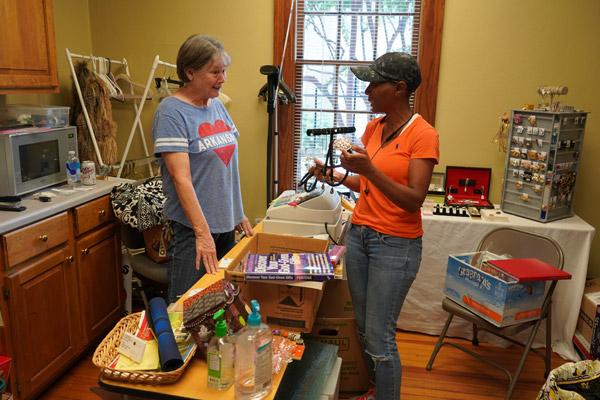 St. Edward Thrift Store customer Deneen Hill chats with LeAnn Wellinghoff, cofounder of the thrift store, about her purchases before checking out Sept. 13. The store opened in May 2020 and has brought in $41,552 for St. Edward Church in Little Rock. (Aprille Hanson Spivey photo)