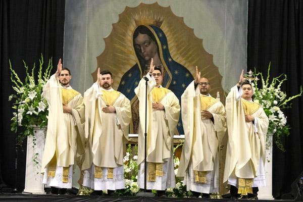 Fathers Ben Riley, Brian Cundall, Omar Galván, Emmanuel Torres and Alex Smith bless the congregation at the end of the ordination Mass. (Bob Ocken photo)