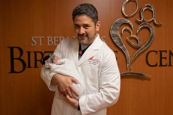 Dr. Enrique Gomez, a neonatologist and pediatric hospitalist for St. Bernards Medical Center in Jonesboro, holds his niece, whom he delivered in February. He said it’s been emotionally hard to separate COVID-19 positive mothers from their newborns. (Photo courtesy St. Bernards Medical Center)