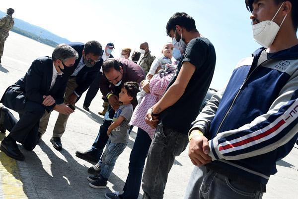 U.S. Secretary of State Antony Blinken speaks with a child as he meets an Afghan refugee family at Ramstein Air Base in Germany Sept. 8, 2021. (CNS PHOTO/OLIVIER DOULIERY, POOL VIA REUTERS)