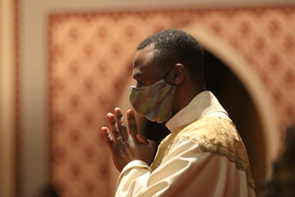Father Leon W. Ngandu, SVD, pastor of St. Augustine Church in North Little Rock and St. Bartholomew Church in Little Rock, prays while listening to the Gospel reading at the 35th Annual Dr. Martin Luther King Jr. Memorial Mass at the Cathedral of St. Andrew, Saturday, Jan. 15. (Chris Price photo)