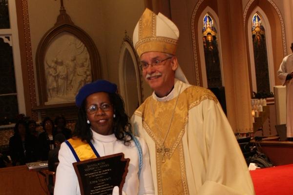 Alma Stewart, a member of St. Bartholomew Church in Little Rock and member of the Knights of Peter Claver Ladies Auxiliary, receives the Daniel Rudd Award from Bishop Anthony B. Taylor Jan. 10, 2015, at the conclusion of the Martin Luther King Jr. Mass. (Malea Hargett photo)
