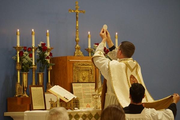 Father Jared McCambridge, FSSP, pastor of St. John the Baptist Church in Cabot, consecrates the Eucharist during the Tridentine-rite Mass following the dedication of the parish's new sanctuary by Bishop Anthony B. Taylor, March 19. The parish relocated to a former Christian church at 602 E. Main Street to allow a larger congregation to attend Masses.
