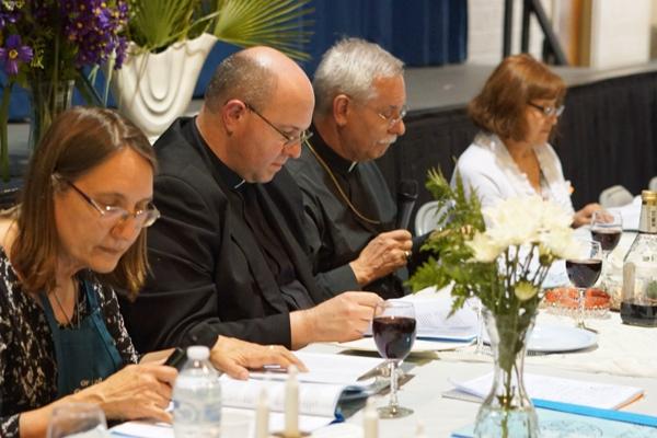 Bishop Anthony B. Taylor (right center) leads the Seder Meal for the first time at Our Lady of Good Counsel Church in Little Rock April 10, with pastor Father Greg Luyet and parishioner Diane Hanley (left) assisting. Malea Hargett photo. 
