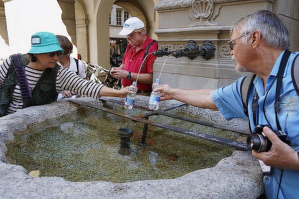 Diane Hanley of Little Rock and Carl Meuer of Holland, Ark., (photo at left) fill their water bottles during a walking tour of Lucerne, Switzerland July 8.