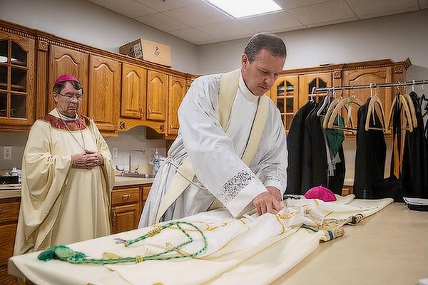 Bishop-elect Erik T. Pohlmeier prepares his vestments before his ordination as the 11th bishop of the Diocese of St. Augustine (Fla.), July 22.