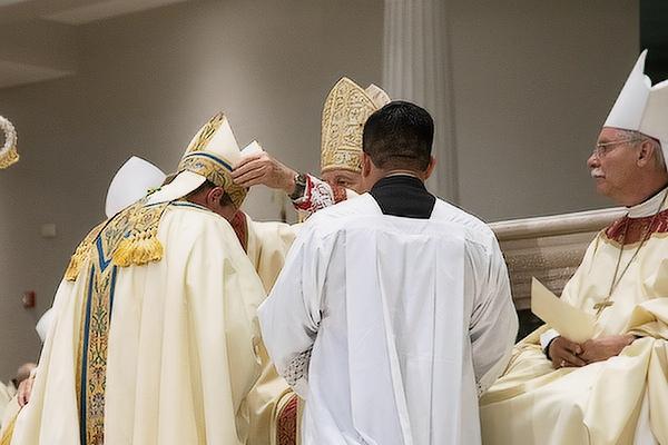 As Bishop Anthony Taylor watches, Archbishop Thomas Wenski of Miami places a miter on Father Pohlmeier's head marking his ordination as bishop at St. Joseph Church in Jacksonville, Fla., July 22.