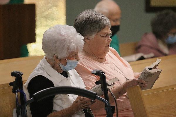 Angelina Zulpo Dunlap and her sister, Virginia Zulpo Strandridge, who both grew up as members of St. Francis of Assisi Church in Little Italy, follow the opening Mass celebrating the 100th anniversary of the parish in Little Italy Aug. 5. (Chris Price photo)