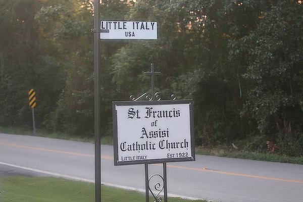 Signs along Highway 300 mark St. Francis of Assisi Church, the center of the community of Little Italy. The church parish celebrated its centennial Aug. 5-7. (Chris Price photo)